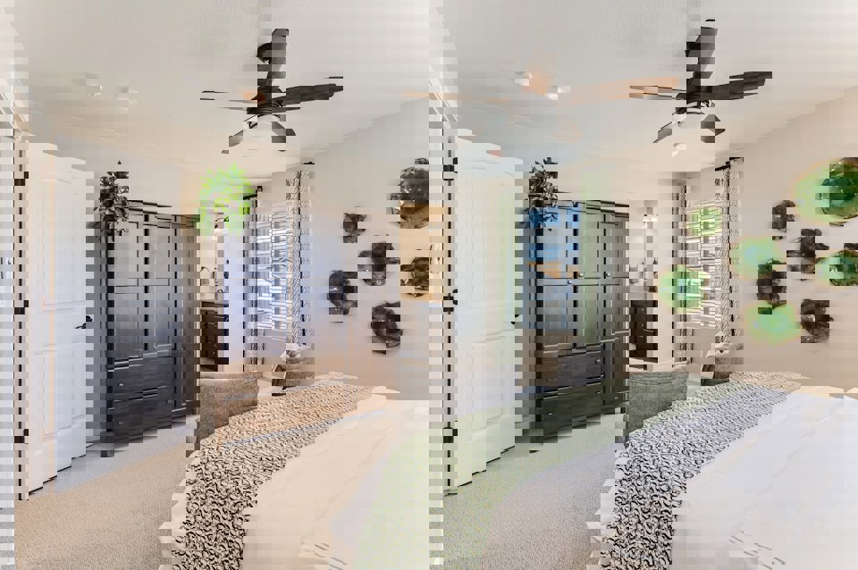 A bedroom with a bed and a fan.