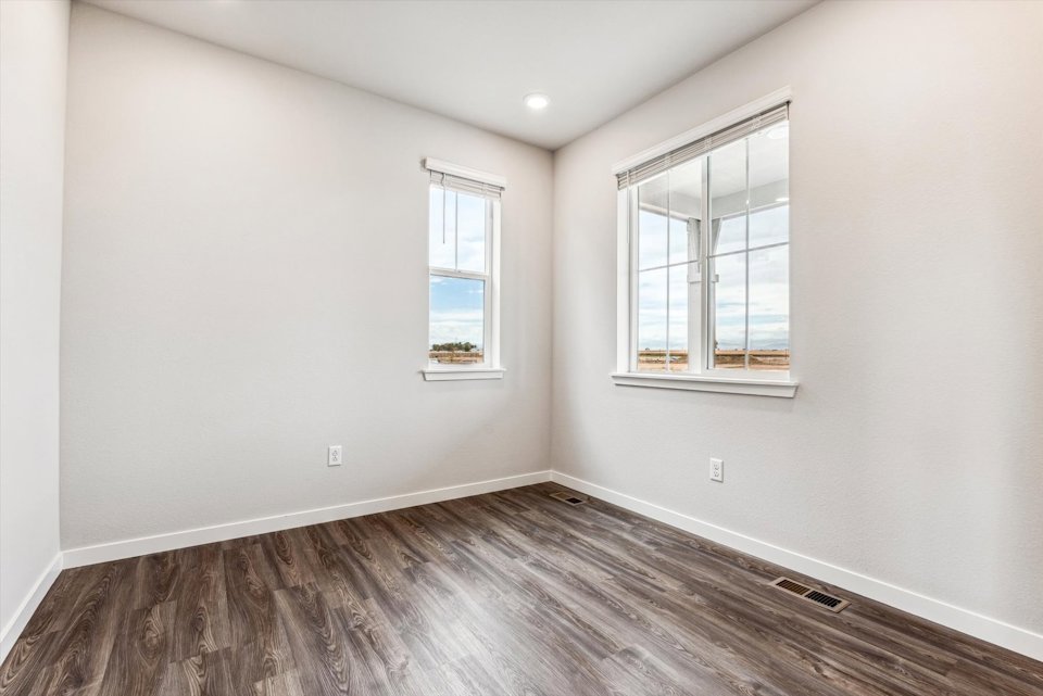 A room with a wood floor and windows.