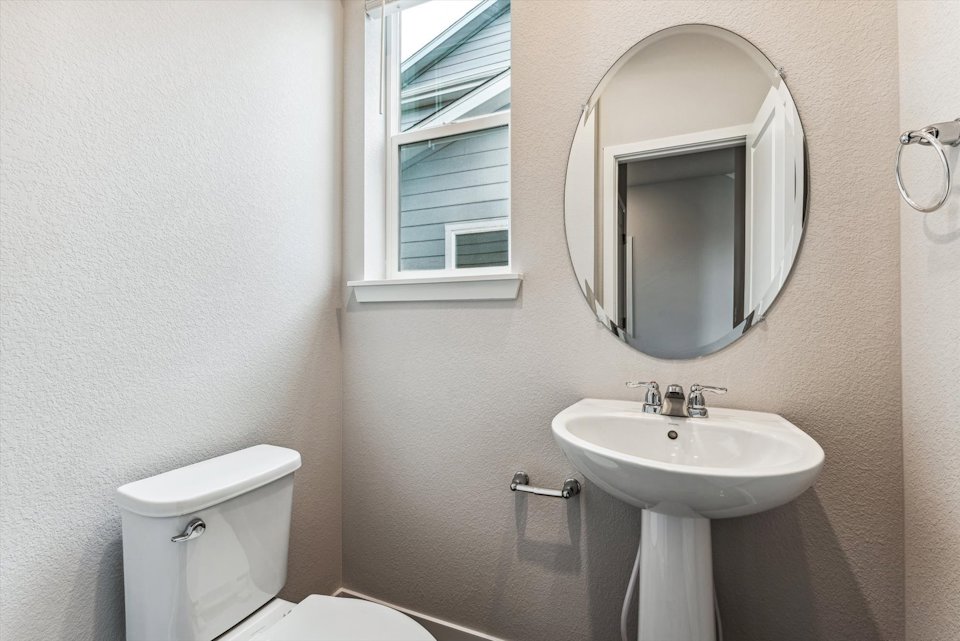 A bathroom with a round mirror.