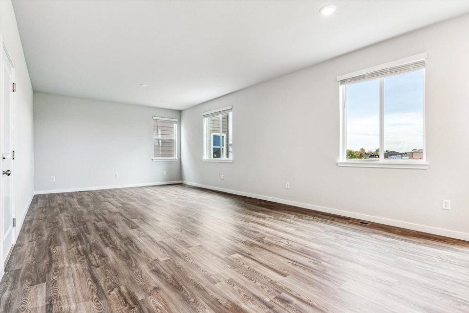 A room with a wood floor and windows.
