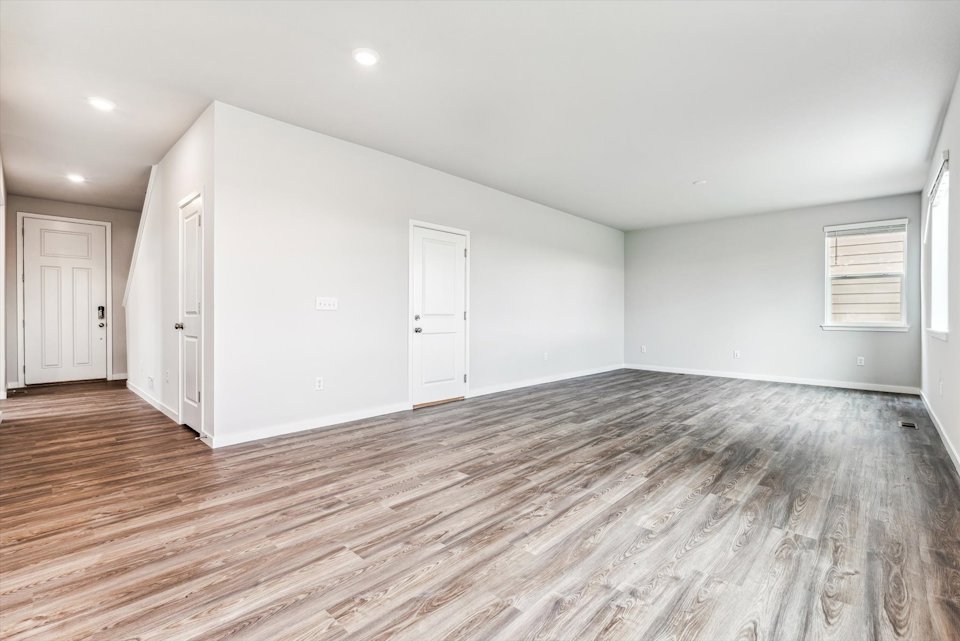 A room with a wood floor and white doors.
