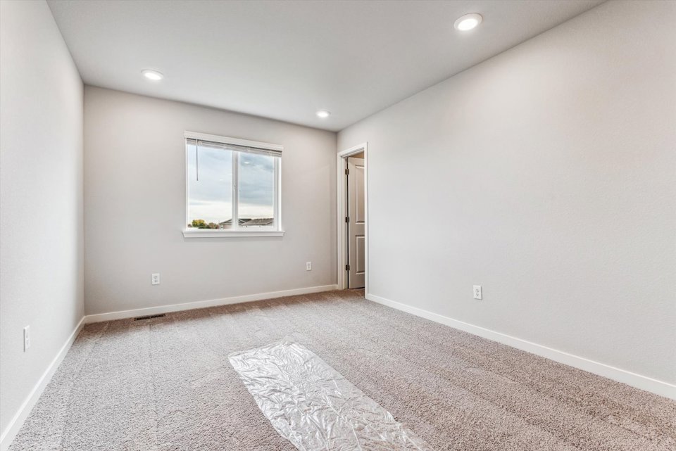 A room with a rug and a window.