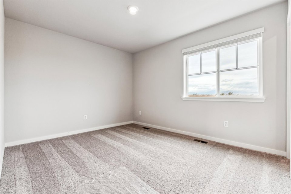 A room with a window and carpet.