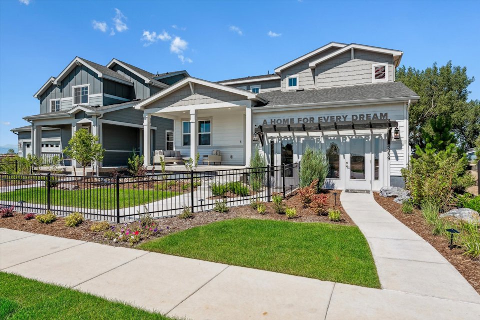 A house with a fence and a lawn in front of it.