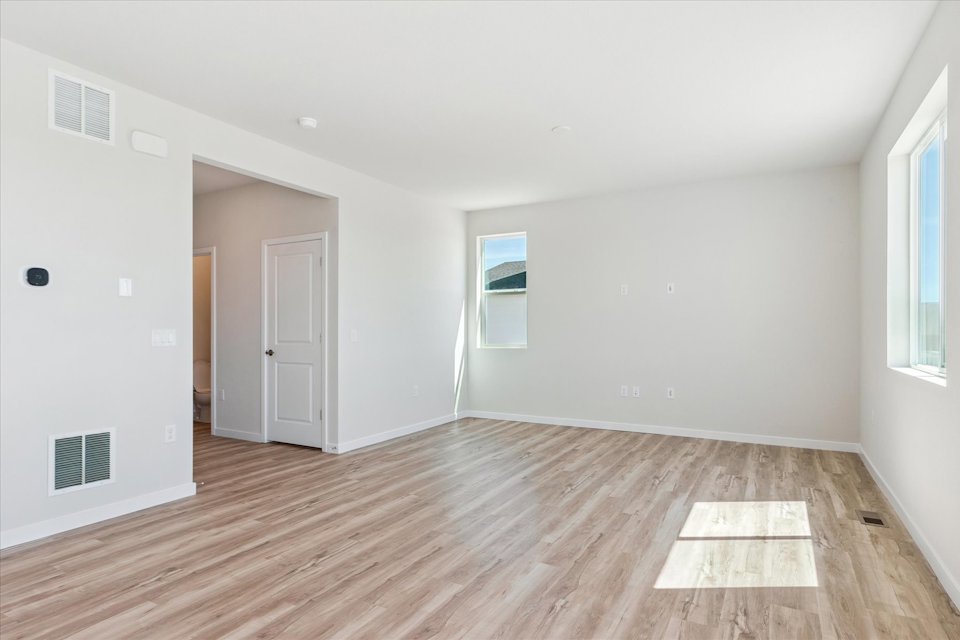A room with a wood floor and white walls.