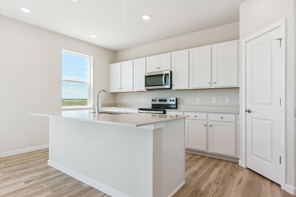 A kitchen with white cabinets.