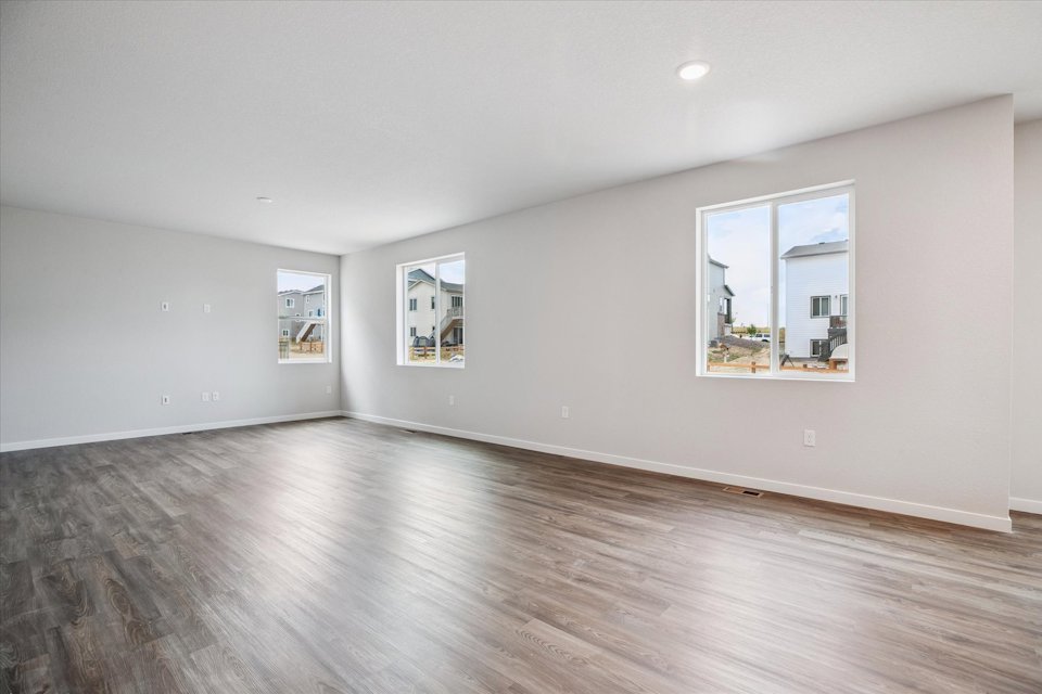 A room with a wood floor and a wood floor with a window.