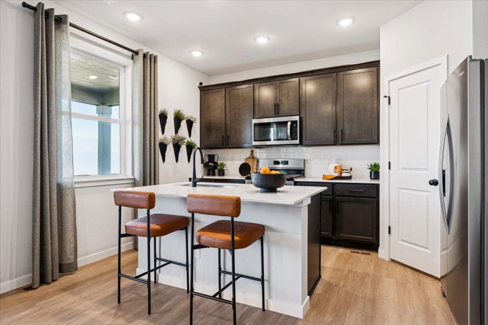 A kitchen with a table and chairs.