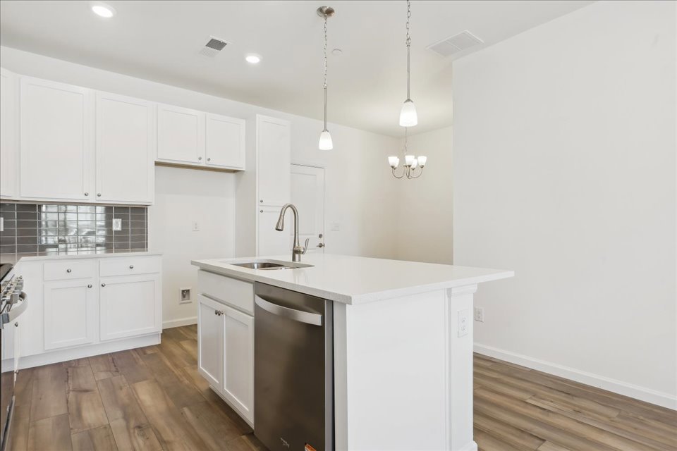 A kitchen with white cabinets.