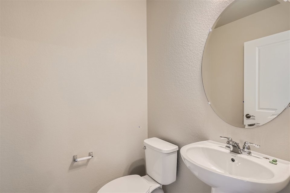 A bathroom with a round mirror.