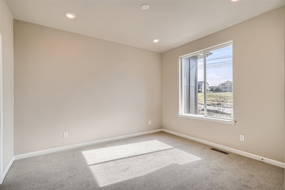 A room with a window and a rug in it.
