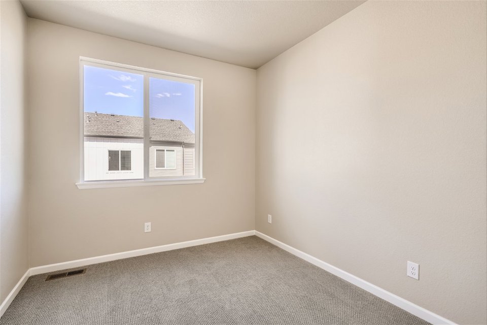 A room with a window and a rug.