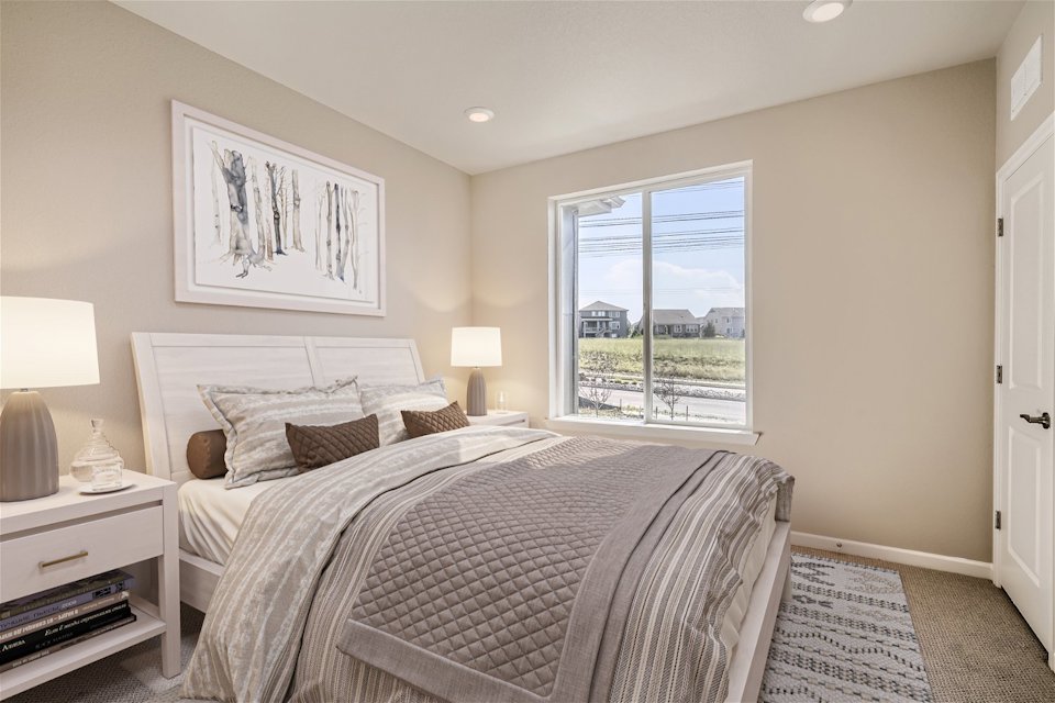 A bedroom with a large window.