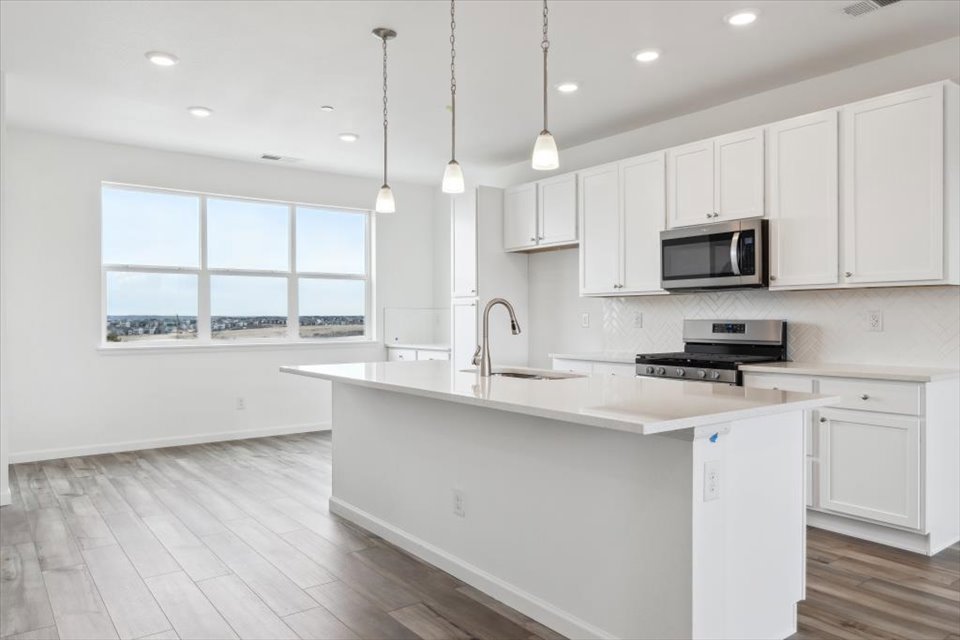 A kitchen with white cabinets.