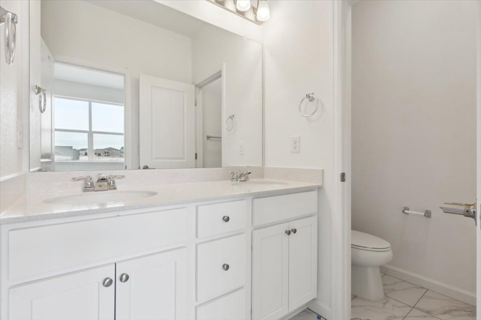 A bathroom with white cabinets.