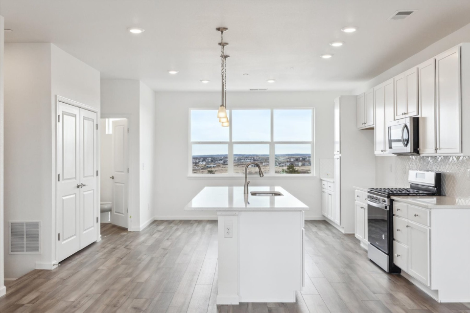 A kitchen with white cabinets.