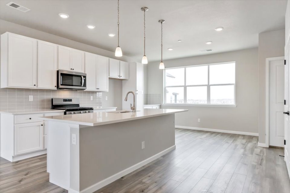 A kitchen with white cabinets.