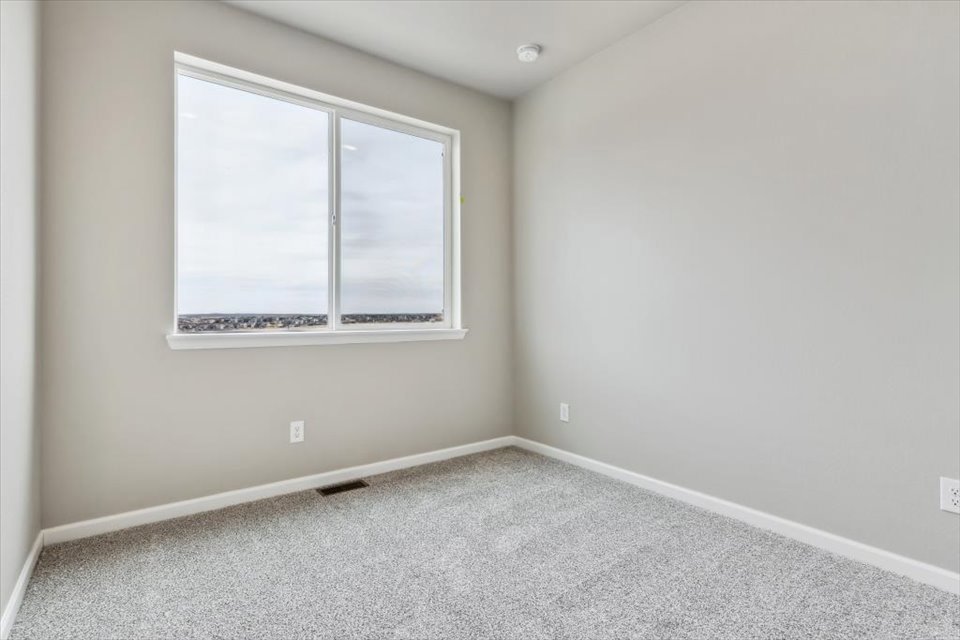 A room with a window and a carpet.