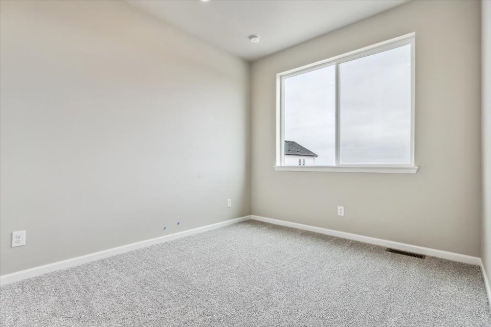 A room with a window and carpet.