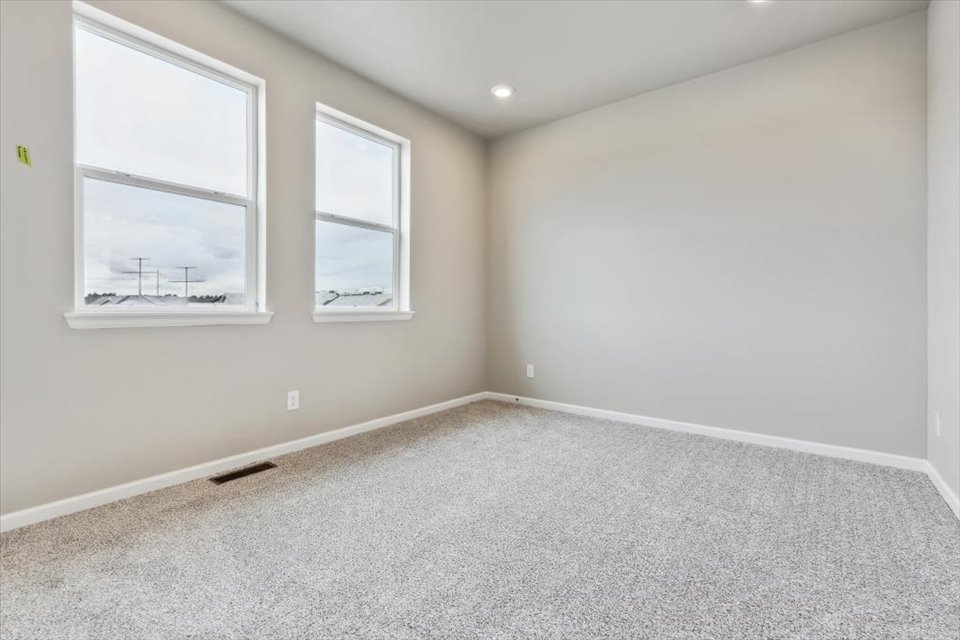 A room with a white wall and windows.