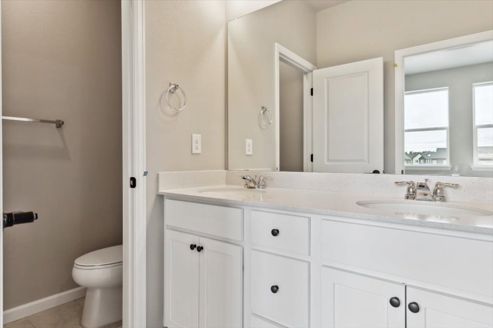 A bathroom with white cabinets.