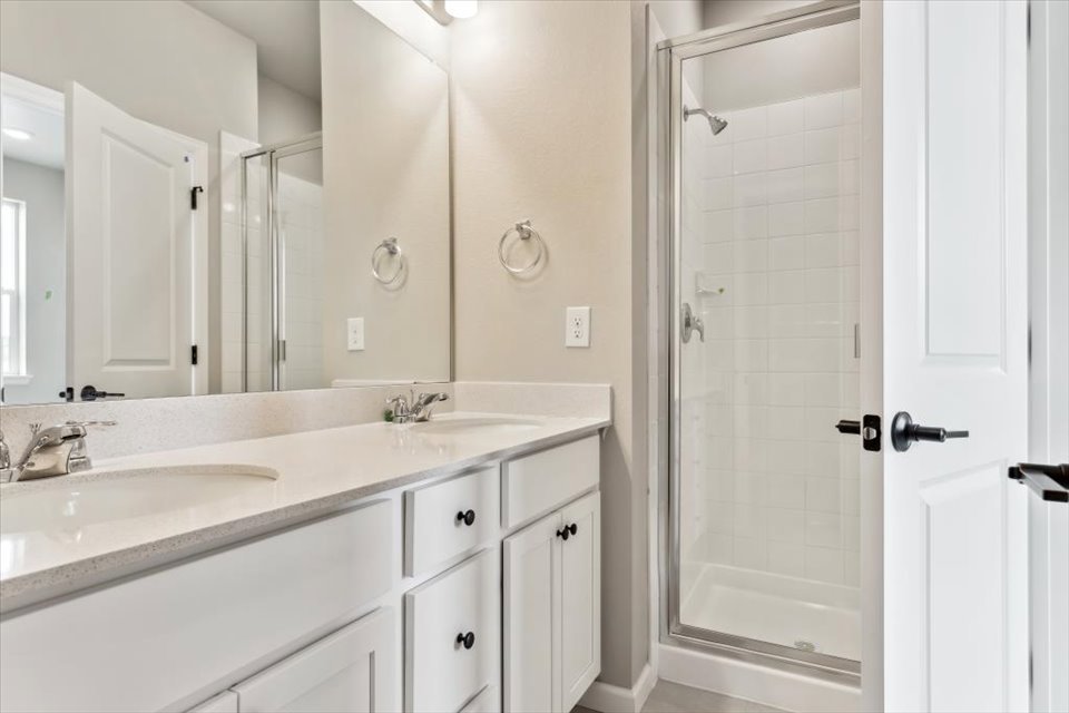 A bathroom with a sink and a shower unit.