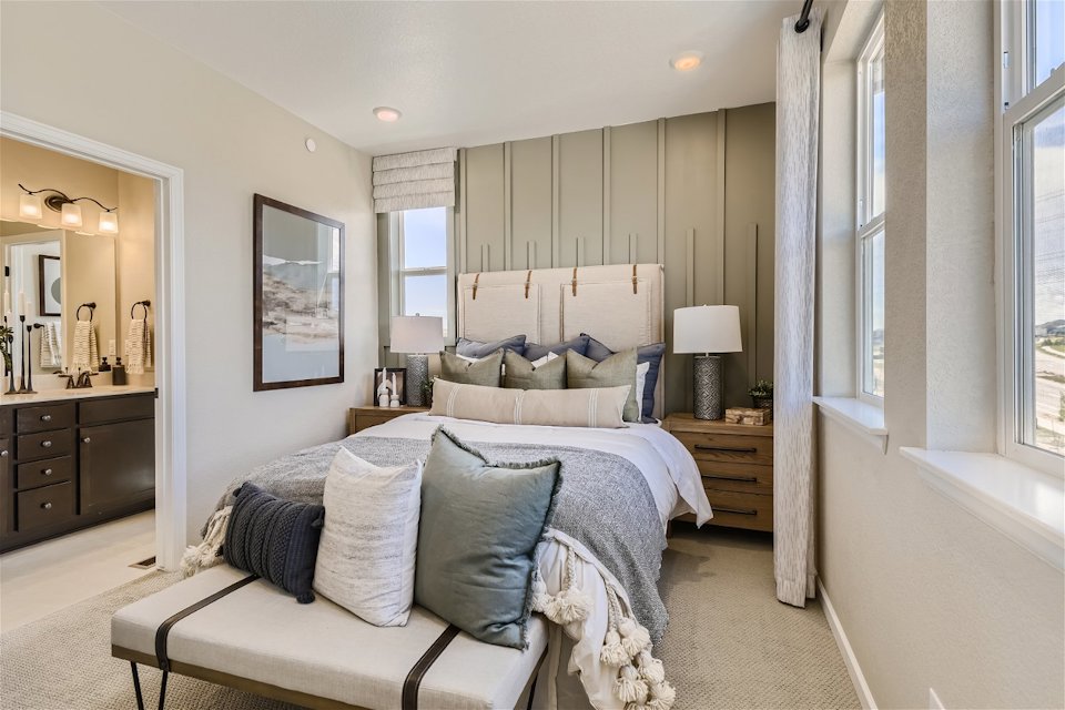 A bedroom with a bed and a chair.