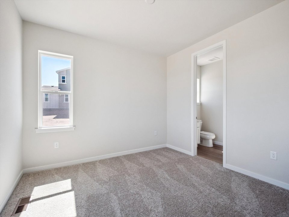 A bathroom with a toilet and a mirror.