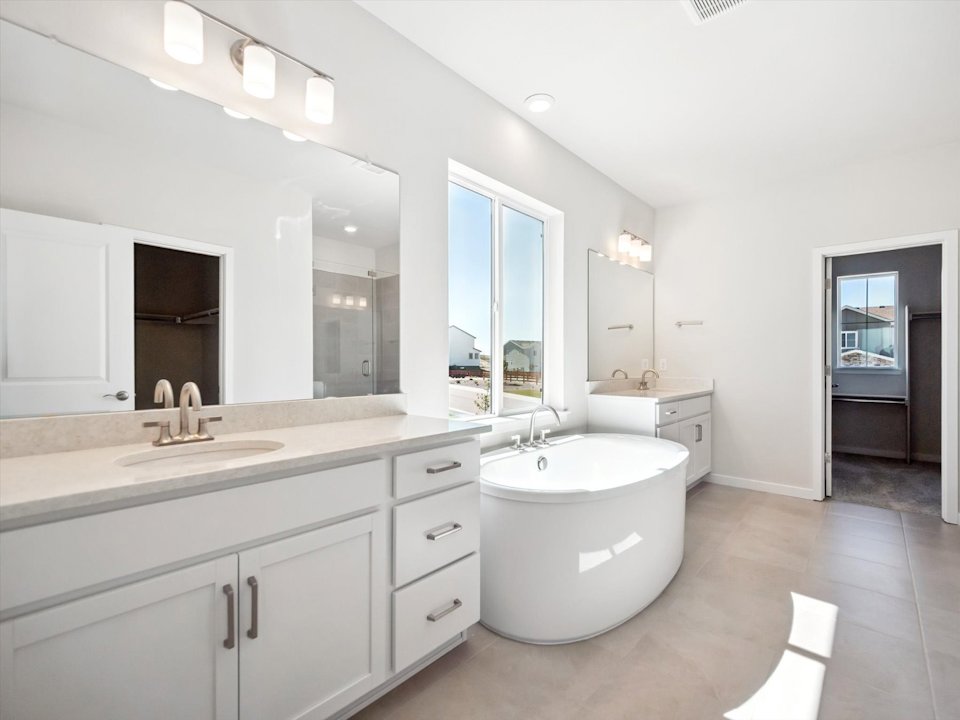 A bathroom with a tub sink and mirrors.
