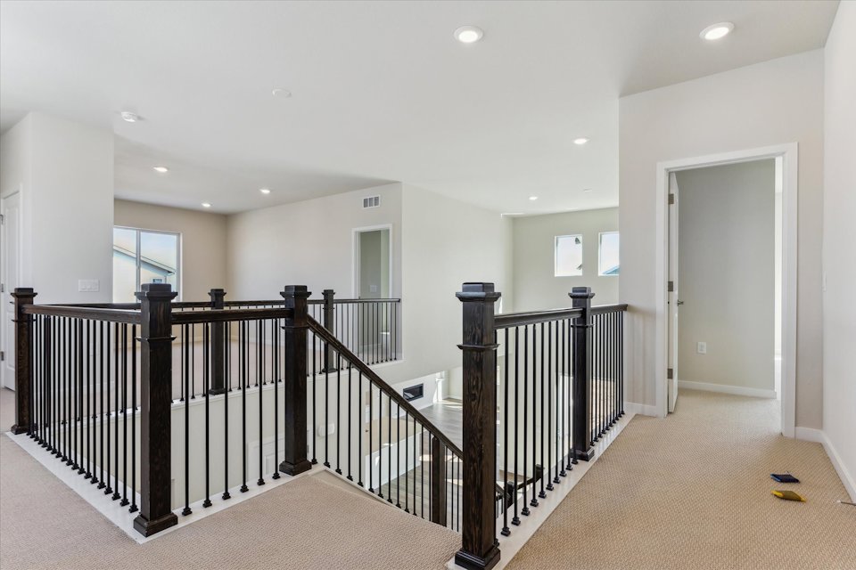 A large white room with black railings and white walls.