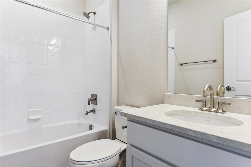 A bathroom with a sink toilet and bathtub.