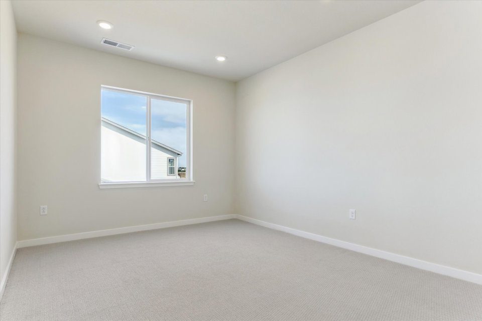 A room with a window and a white wall.