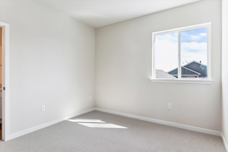 A room with a window and a rug in it.