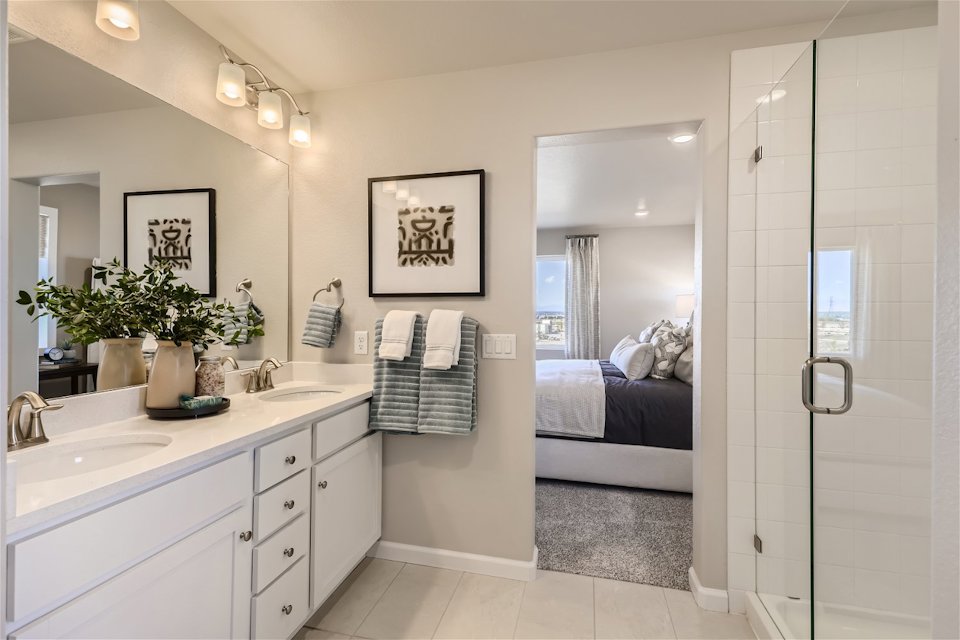 A bathroom with a sink and a bed.