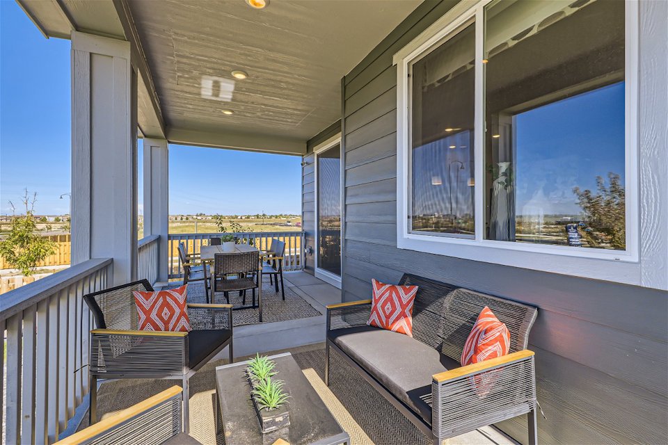 A deck with a couch and chairs.