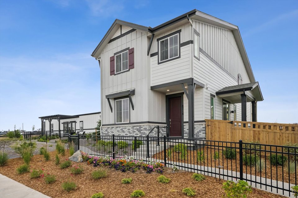 A white house with a black fence.