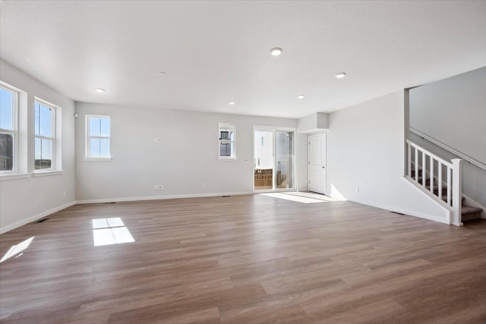 A room with a wood floor and windows.