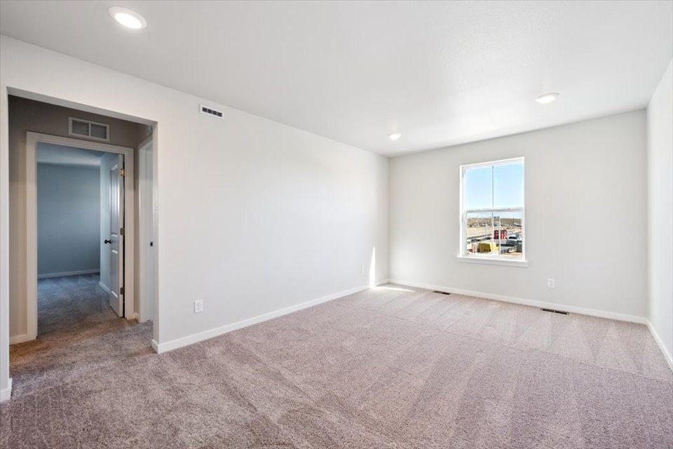 A room with a carpet and a door.