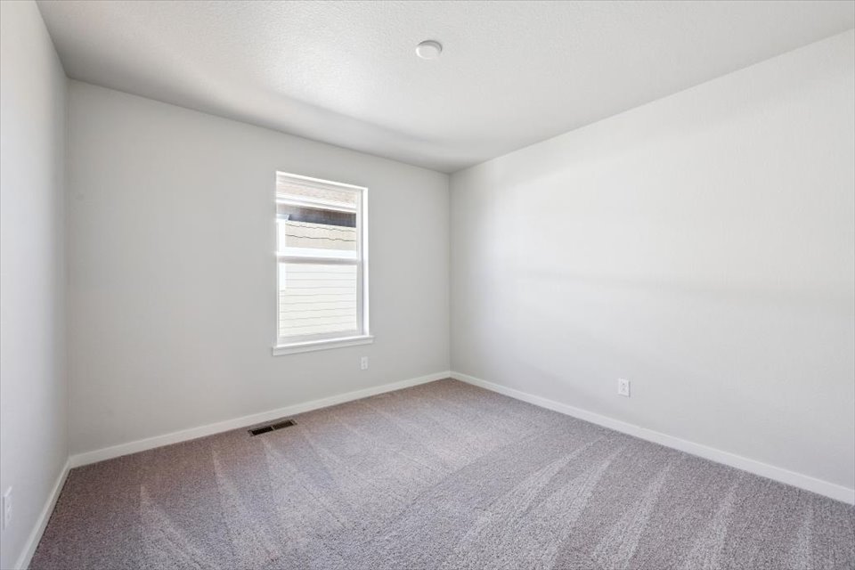 A room with a window and a carpet.