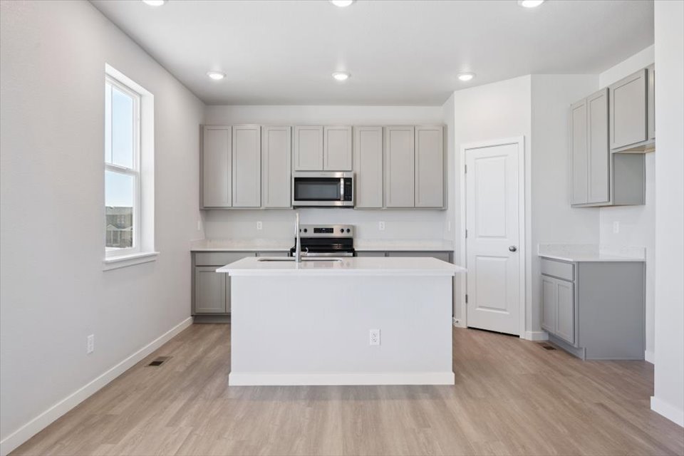 A kitchen with white cabinets.