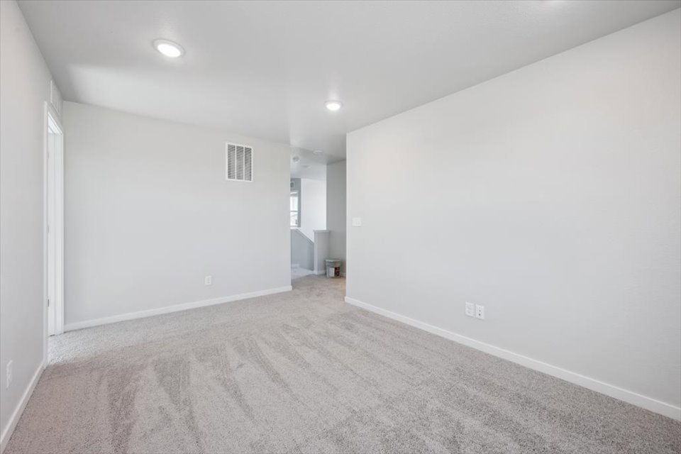 A room with a carpet and a white wall.