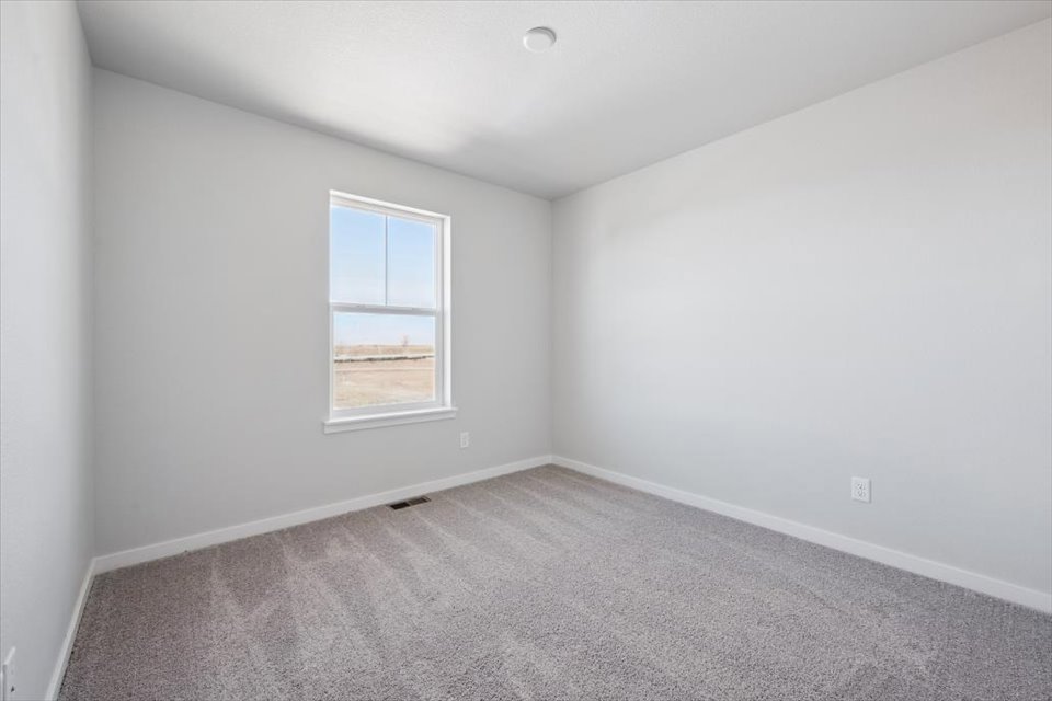 A room with a window and carpet.