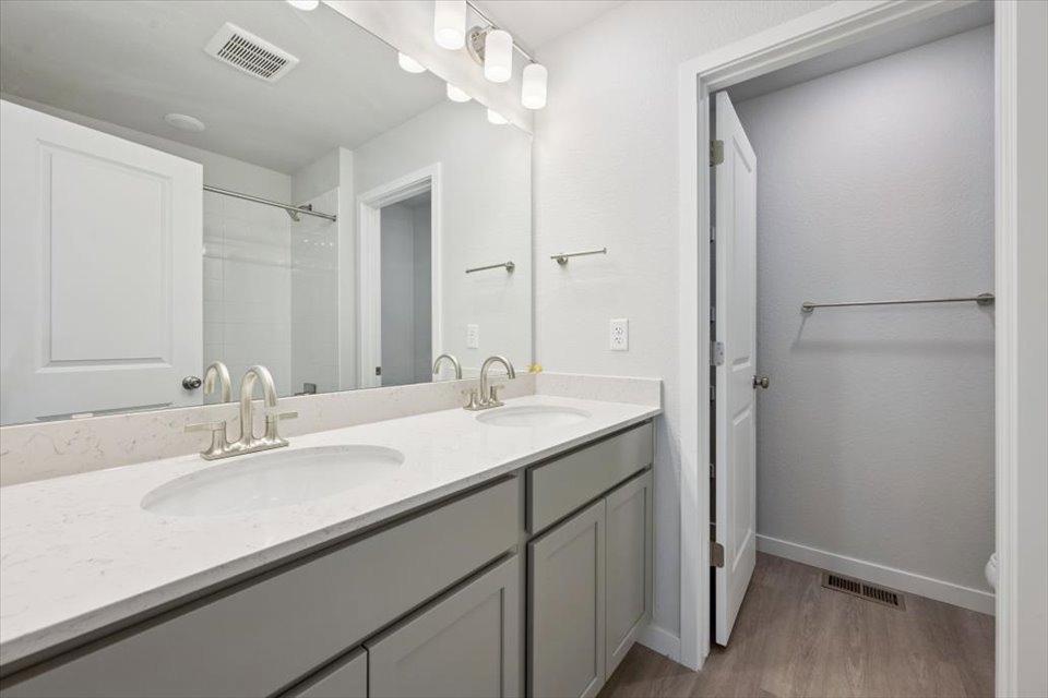A bathroom with a sink and a shower unit.