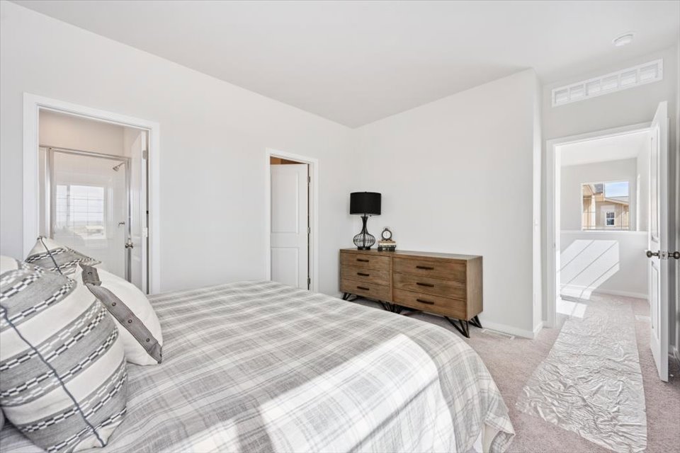 A bedroom with a bed and a dresser.