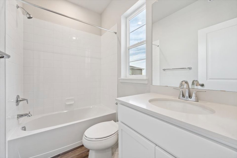 A bathroom with a tub sink and toilet.