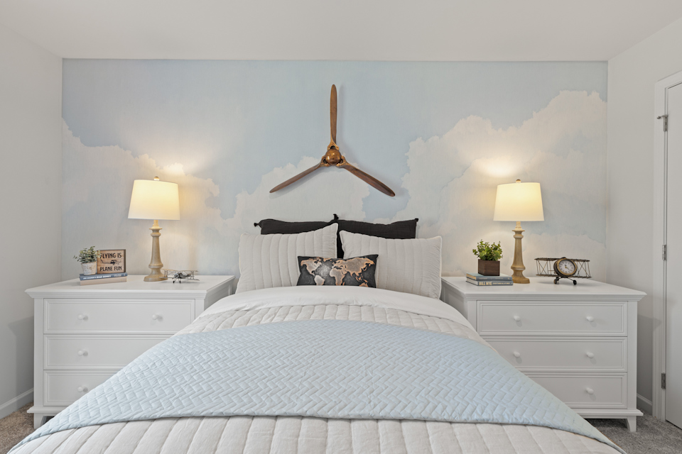 A bed with a white bed spread.