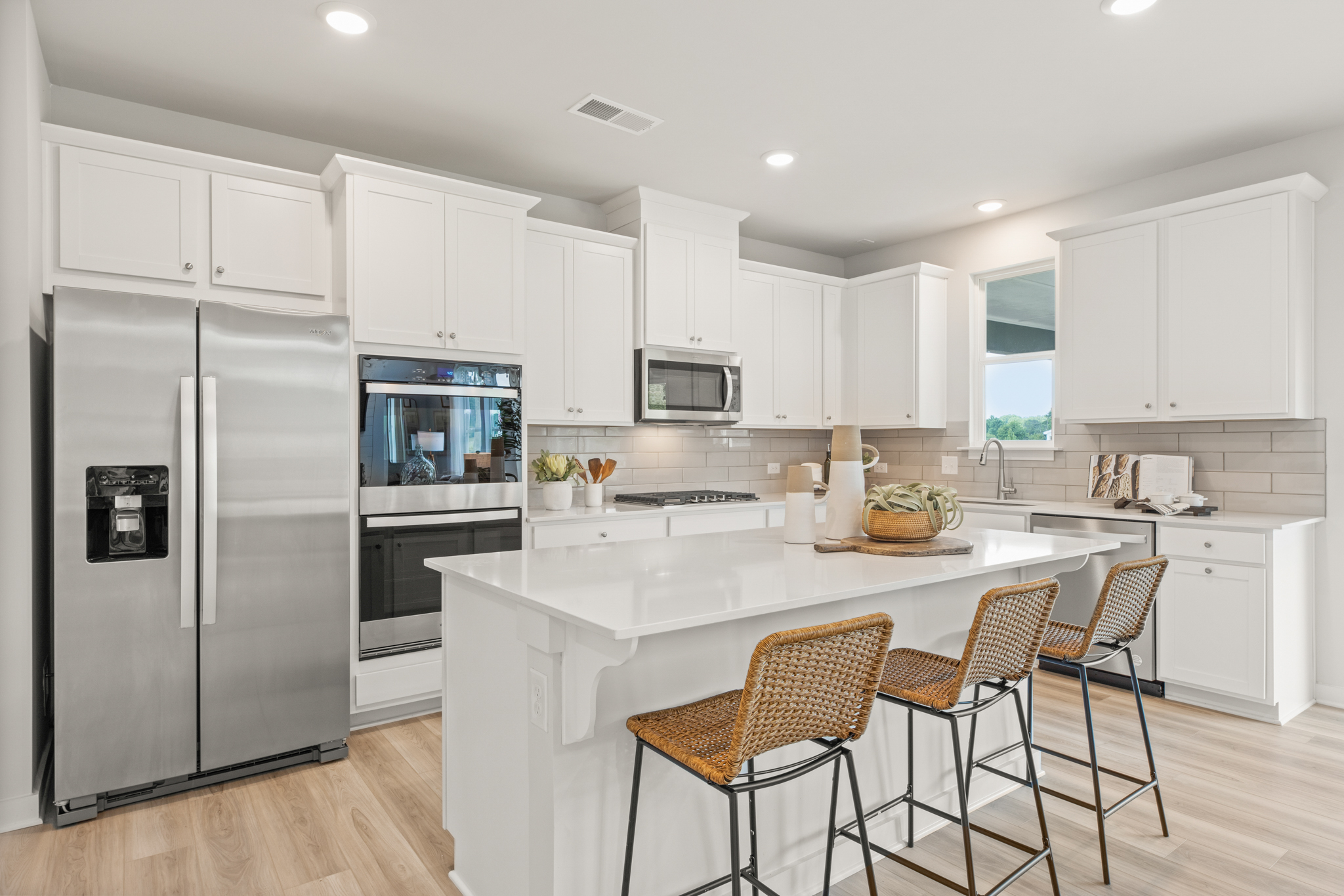 A kitchen with white cabinets.