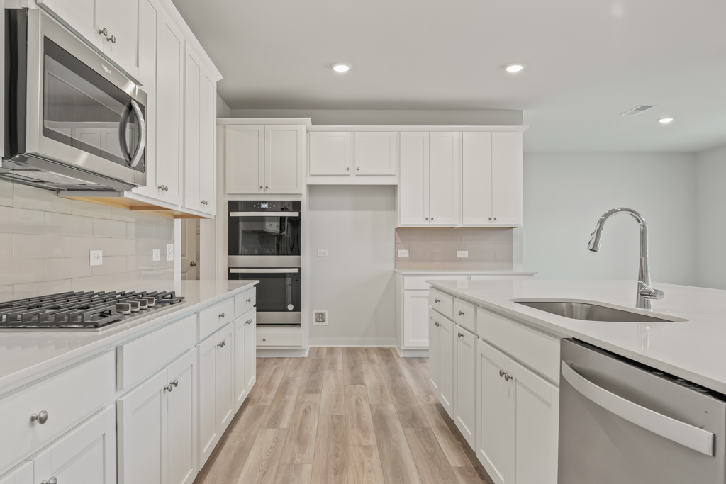 A kitchen with white cabinets.