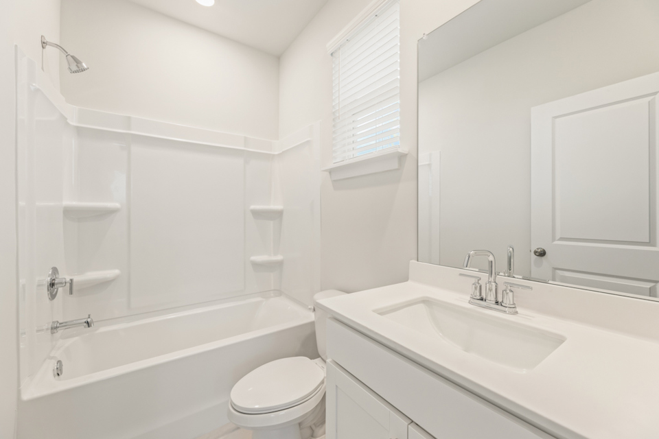 A bathroom with a tub sink and toilet.