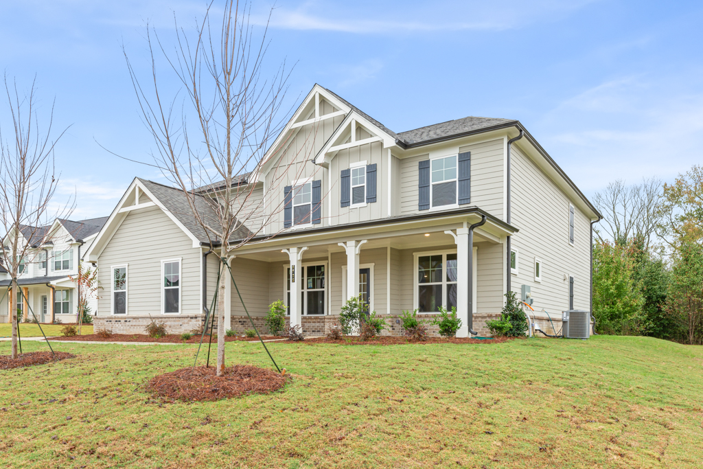 A white house with a lawn in front of it.